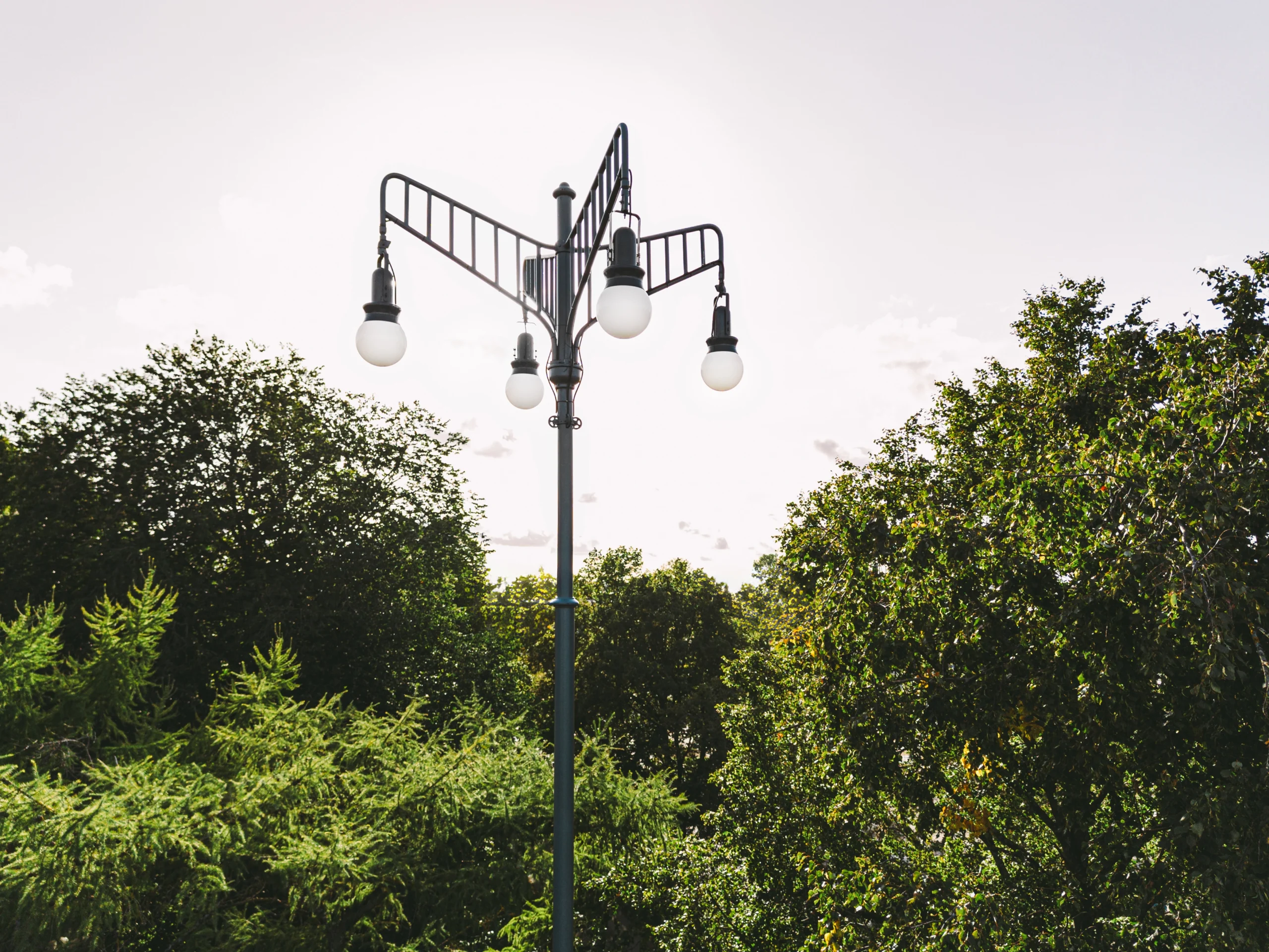 Historical and tailor-made outdoor public space park lighting with a background of trees and greenery at the daytime.