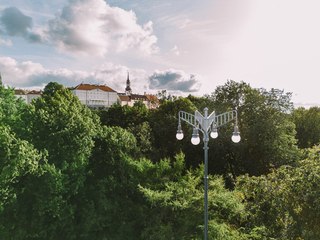 Daytime view of a custom madee historical outdoor light in a park in front of the Estonian Parlament building.