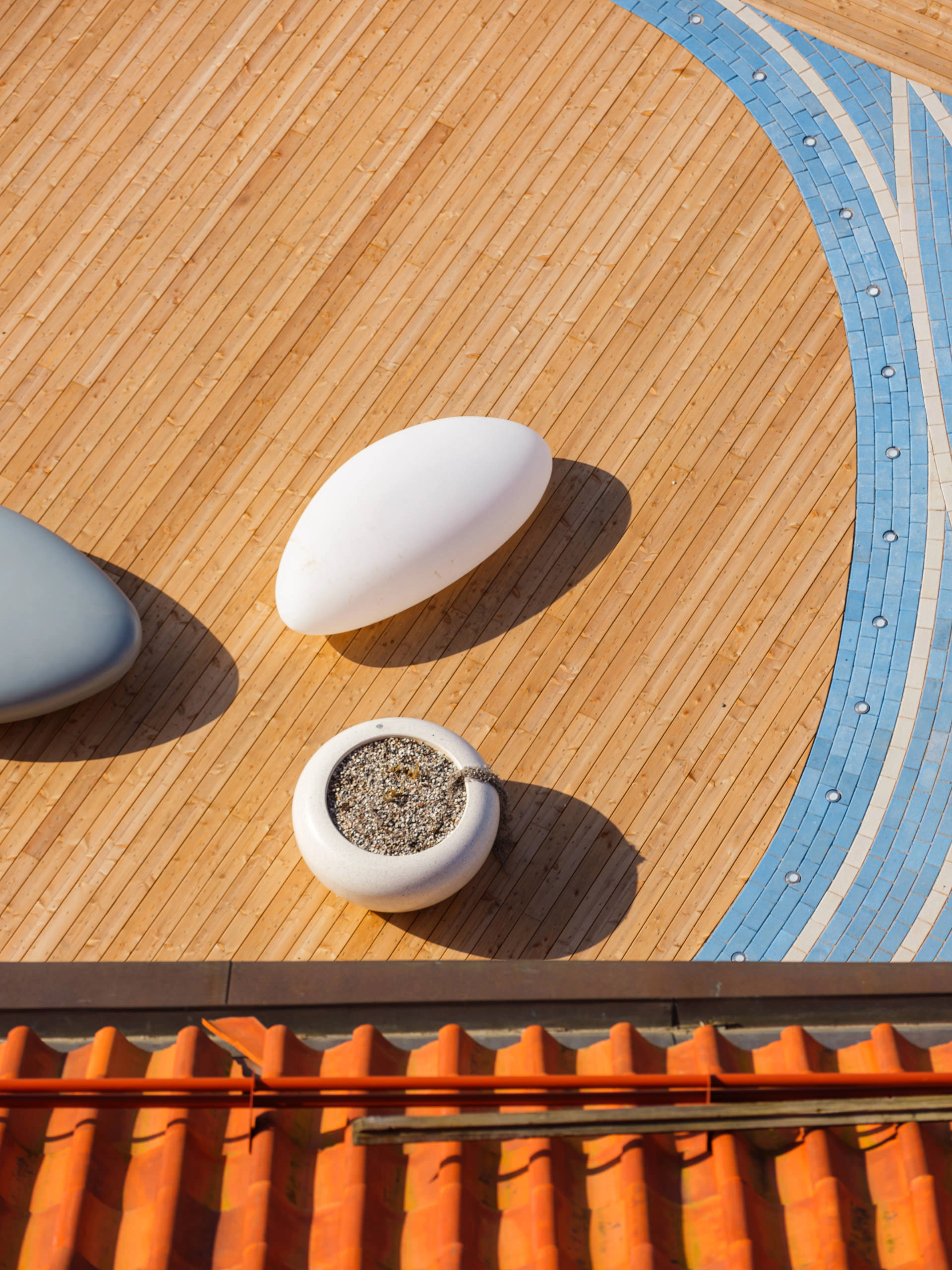 Aerial view of illuminated outdoor furniture with pebble-inspired seating on a wooden deck.