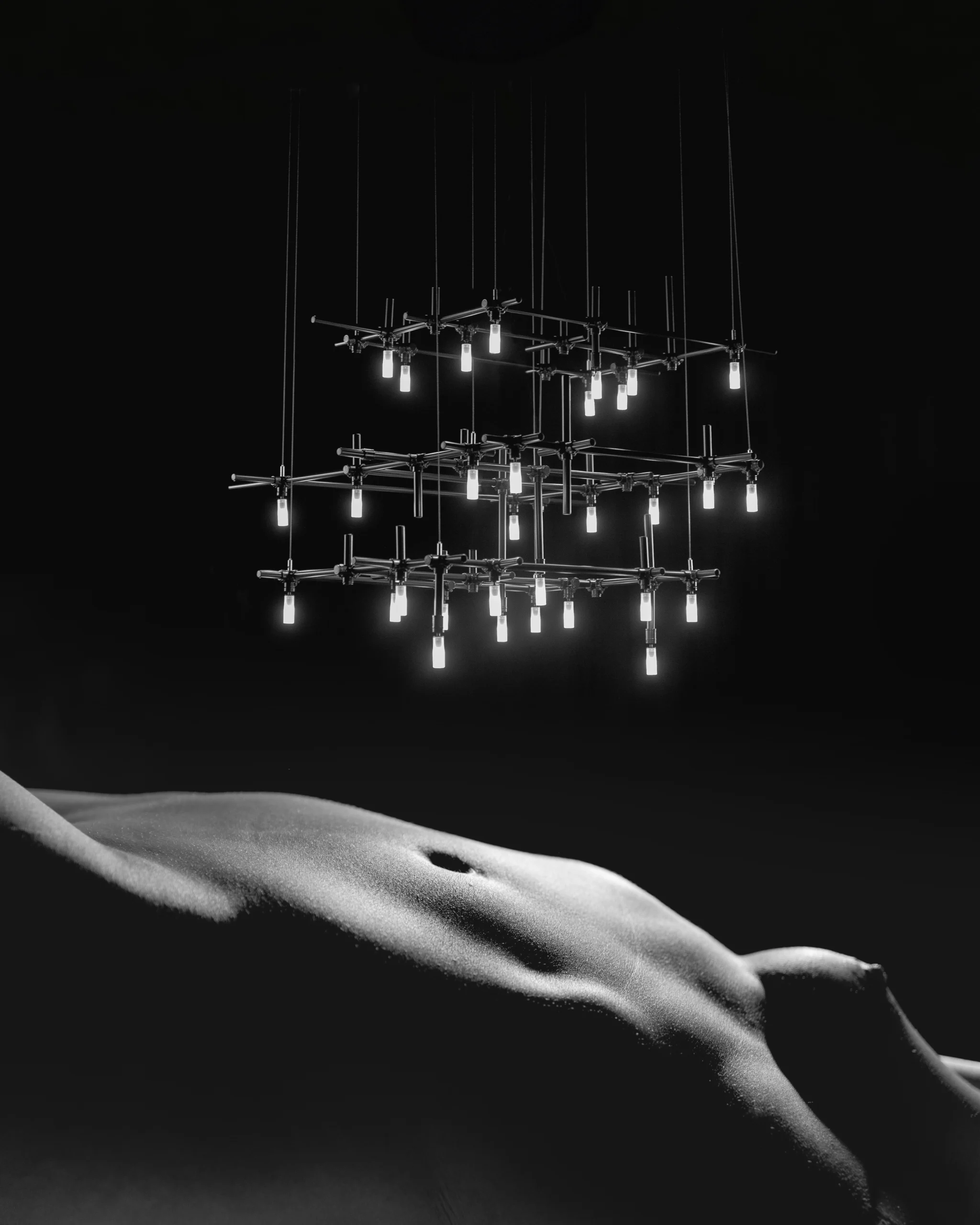 HEXA architectural pendant light casting a soft glow on a monochrome female silhouette.