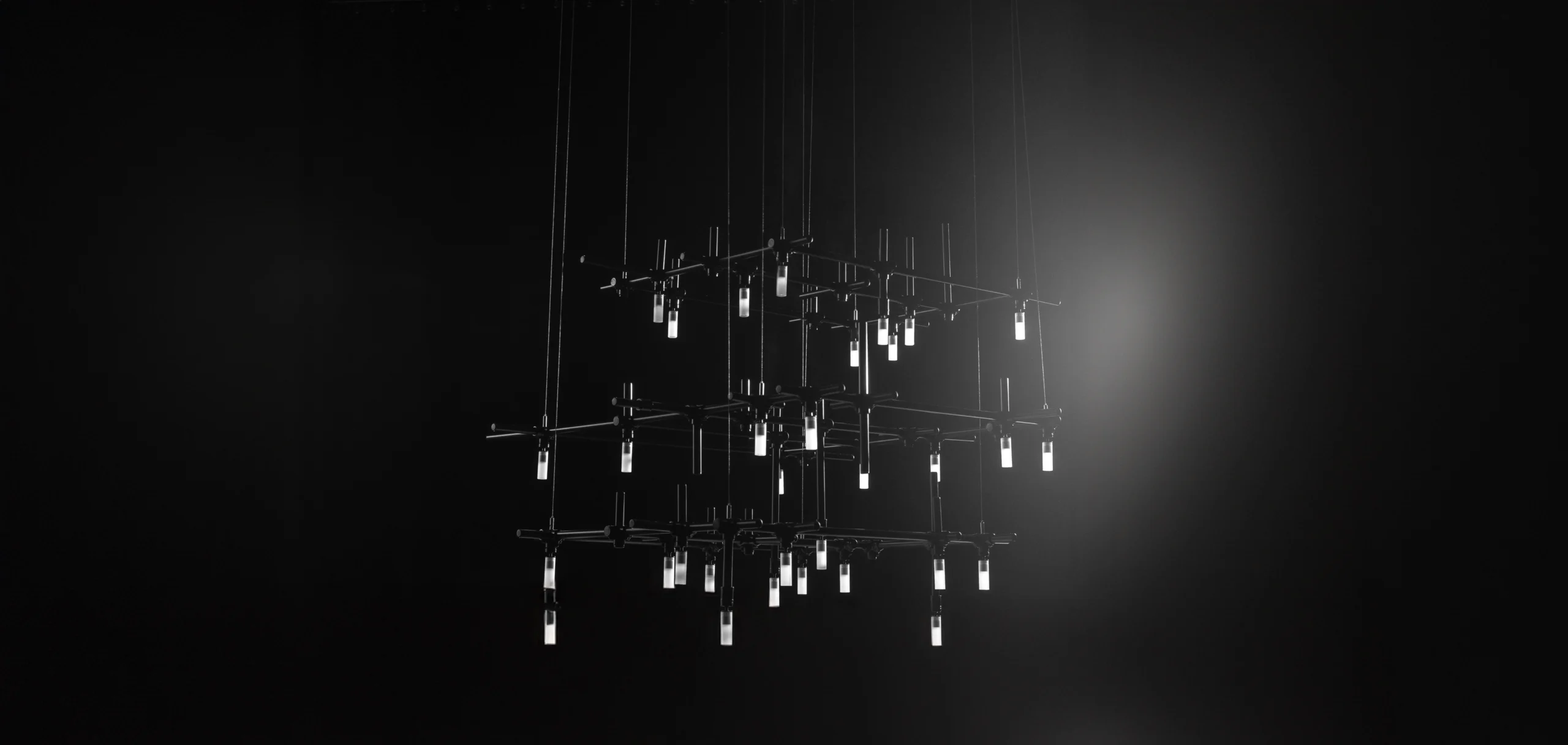 HEXA chandelier’s geometric design featuring cast iron fittings and glass elements