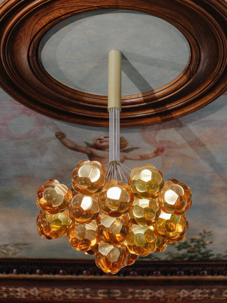 Hanging bunch of amber resin Cloudberry forms beneath a cherub fresco, embassy in Berlin