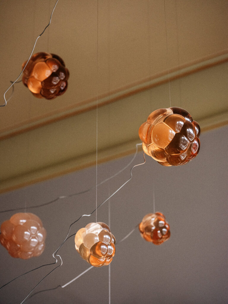 Amber resin Cloudberry forms on cables against a pale green cornice, Estonian Embassy in Berlin