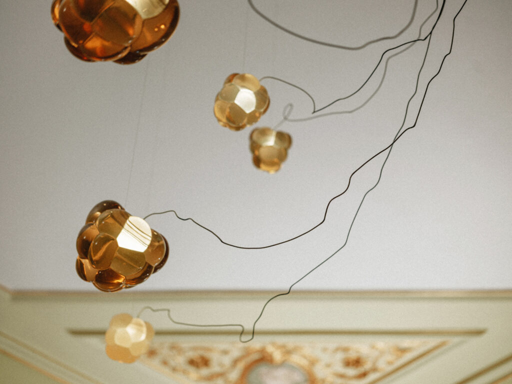 Warm amber resin Cloudberry forms on cables by a gilded ceiling, Estonian Embassy in Berlin