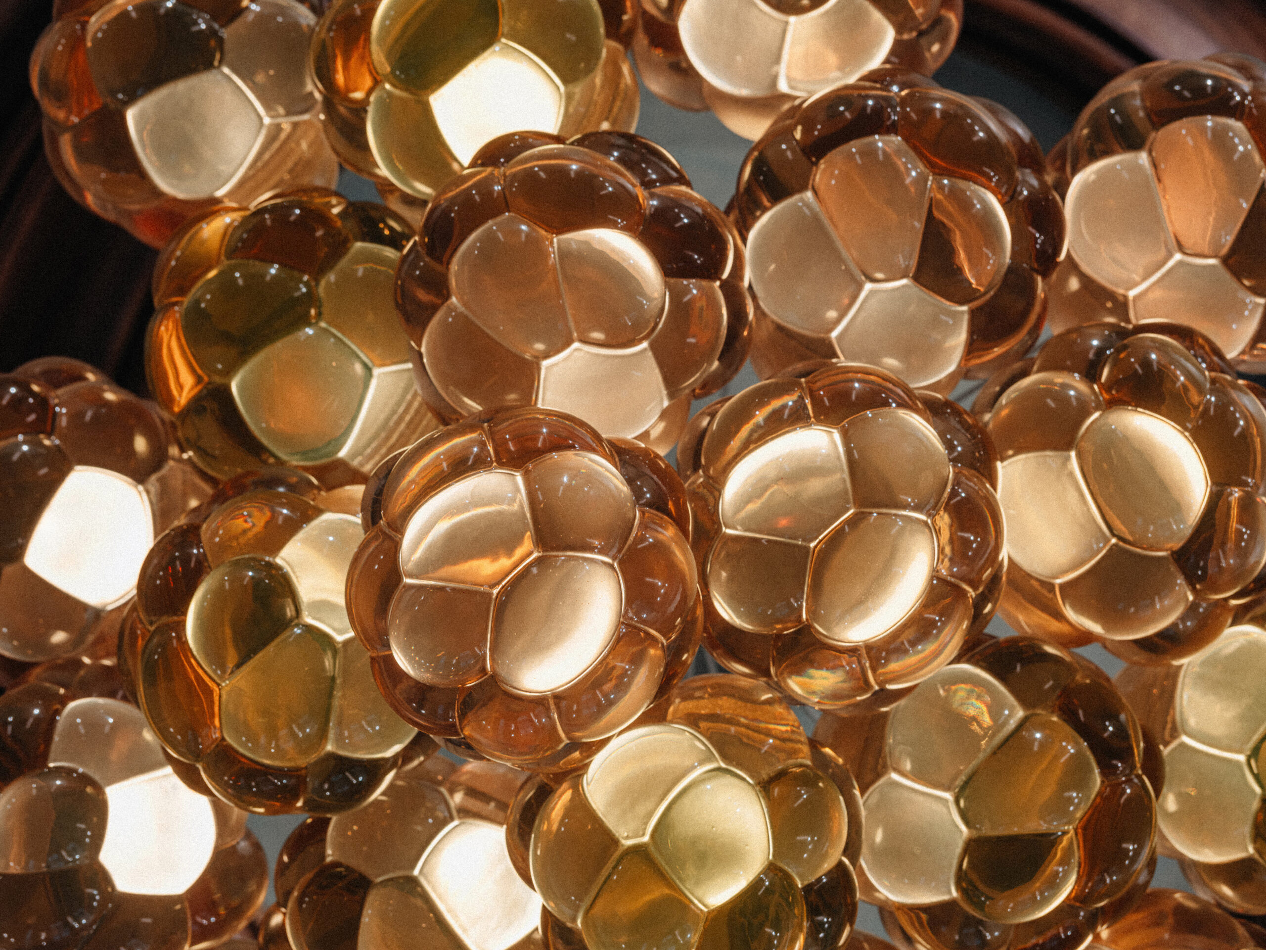Macro of packed amber cast resin Cloudberry forms, translucent and faceted, Berlin