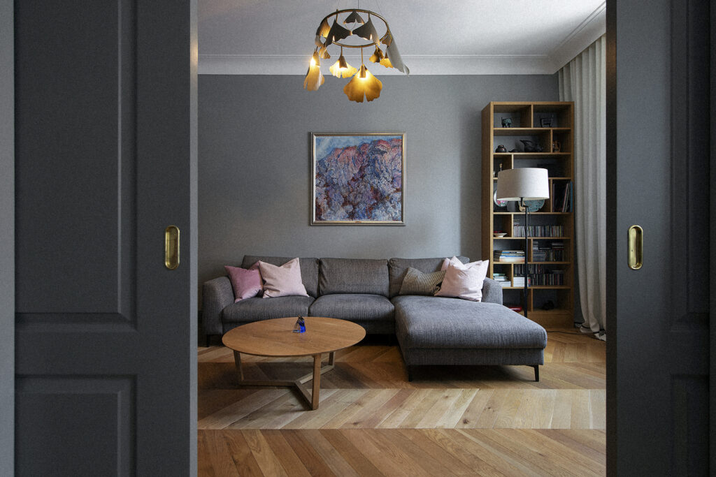 Brass Ginko chandelier in a snug living room seen through open doors, Stockholm