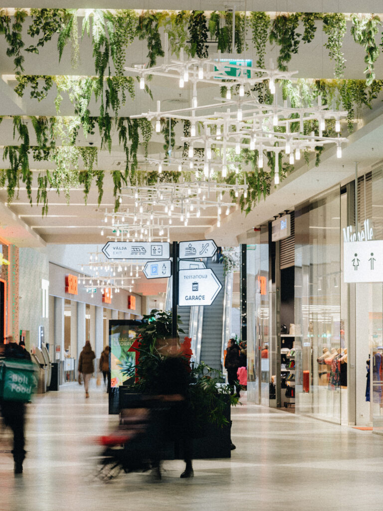 HEXA installation running along the T1 Mall ceiling above shoppers, Tallinn