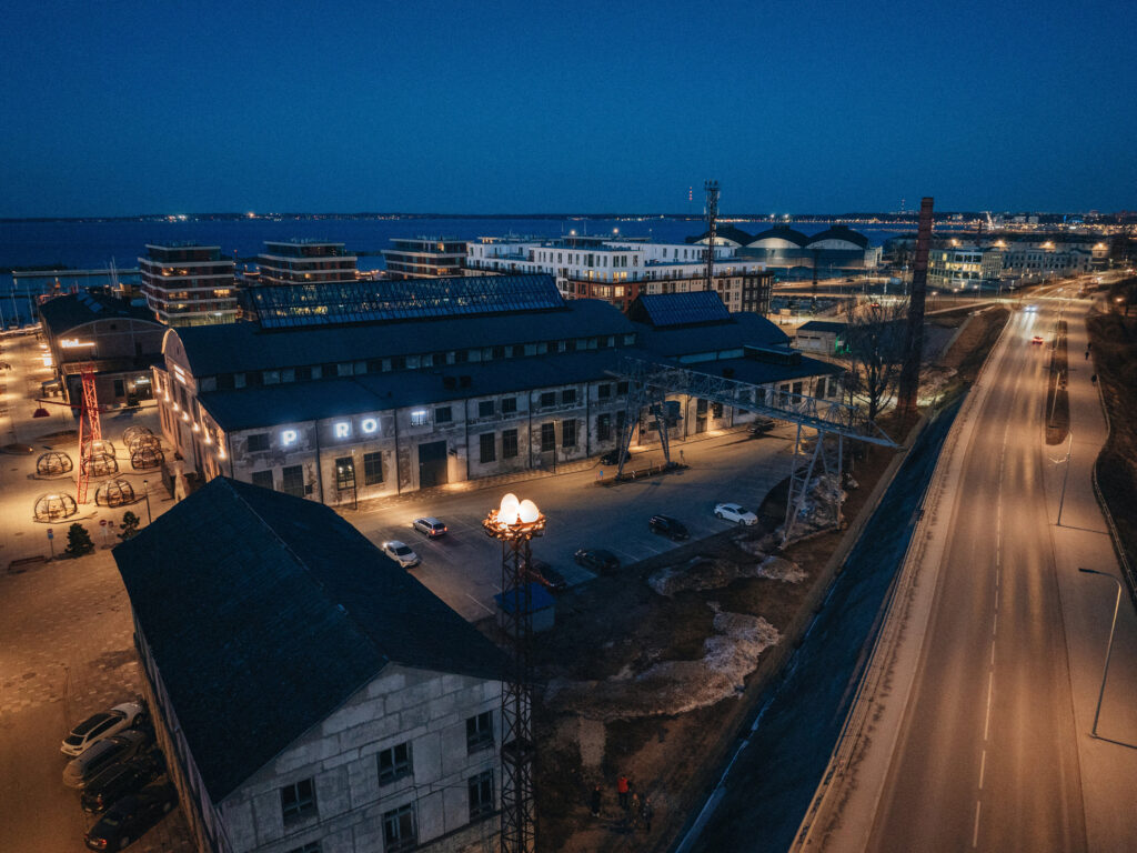 Aerial night view of the glowing Nest over the Noblessner harbour and sea, Tallinn
