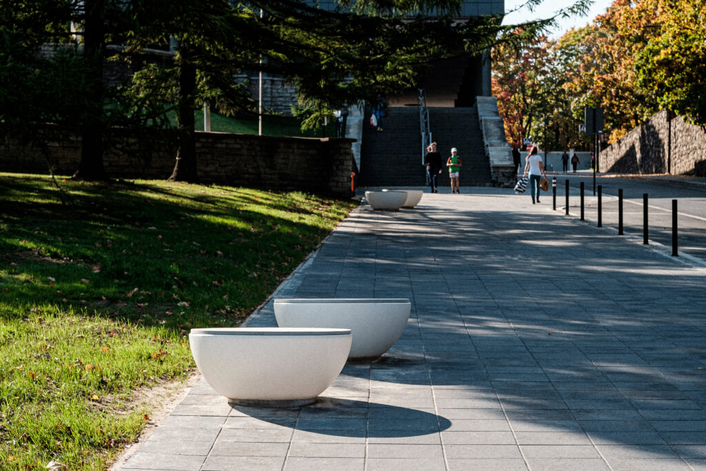Timpan benches along a sunlit Vanemuise Street promenade with pedestrians, Tartu