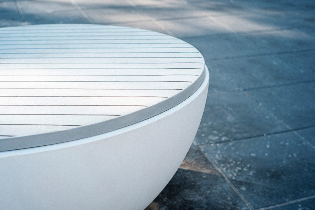 Round synthetic teak seating top and white polyethylene bowl of the Timpan bench, Tartu
