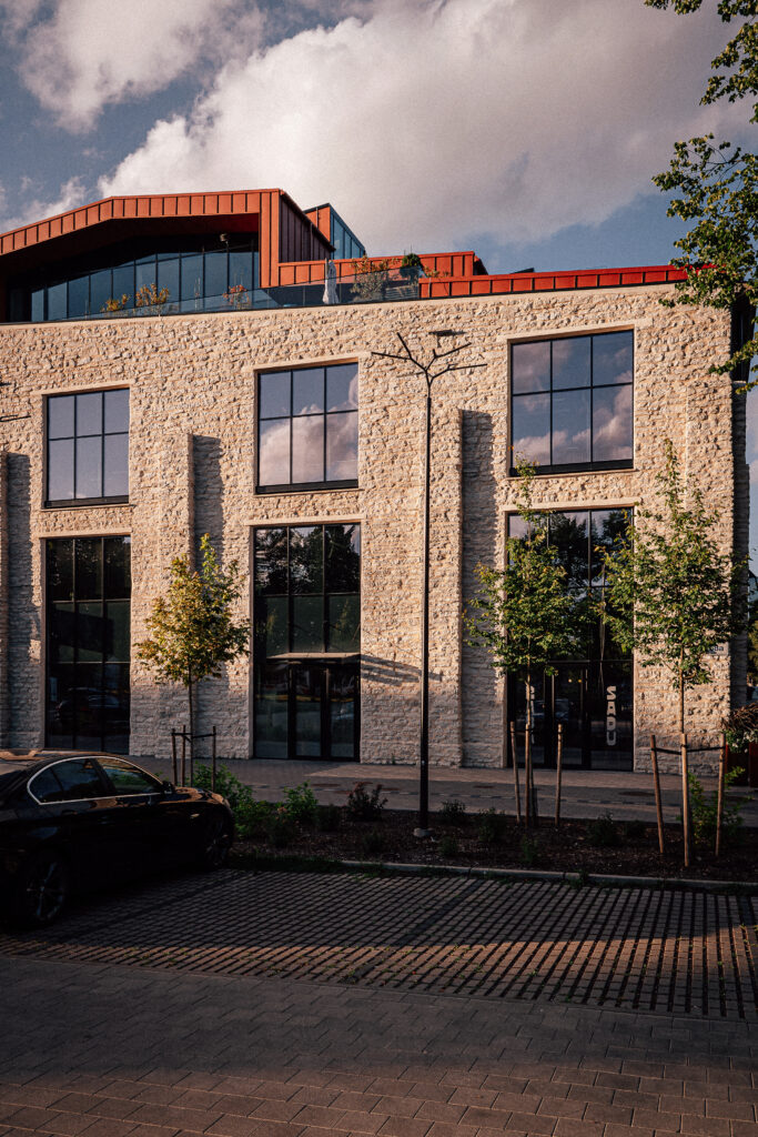 A Branch pole in front of the limestone hall of the former Franz Krull machine works, warm evening sun on the stone