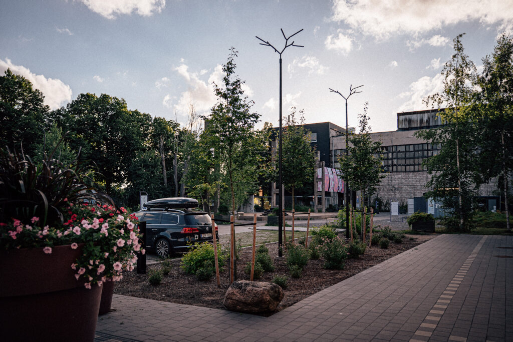 Two Branch pole lights above new planting by the parking area, the old limestone factory hall behind