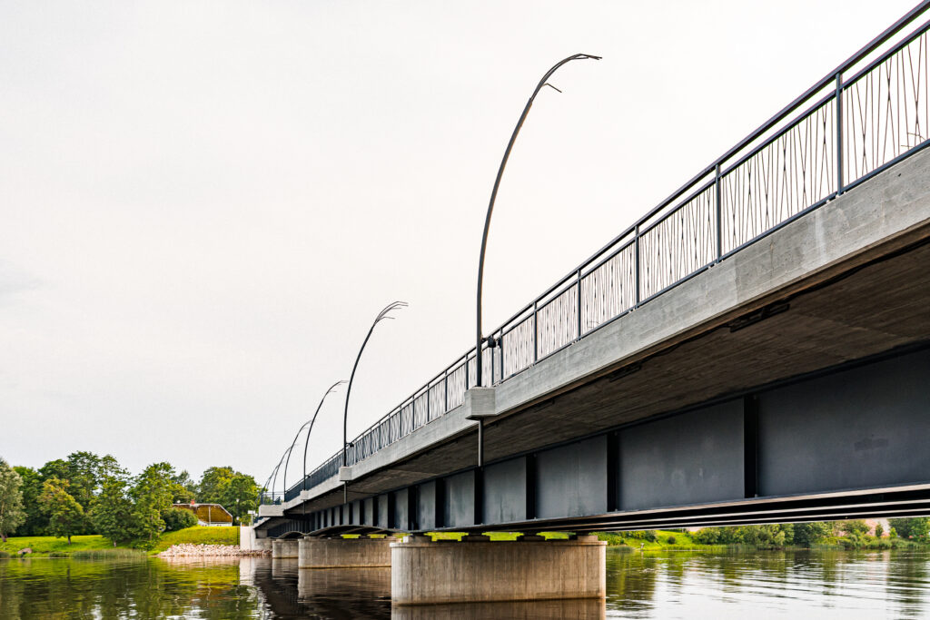 Low angle beneath the Salacgriva bridge, showing the steel girders and the Reed luminaires above the deck.